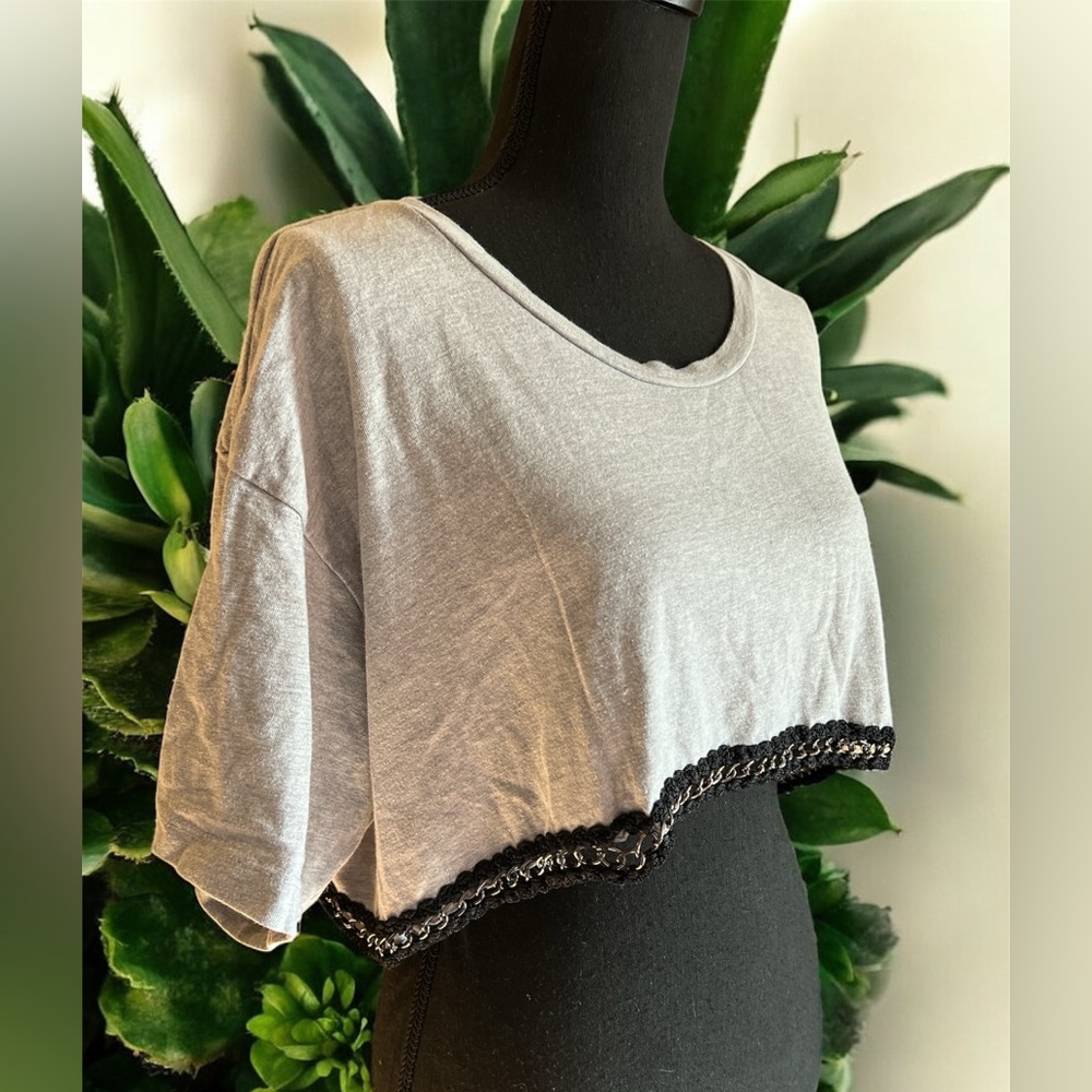This is a grey cropped t-shirt with black lace and chain trim. By Emma & Sam L